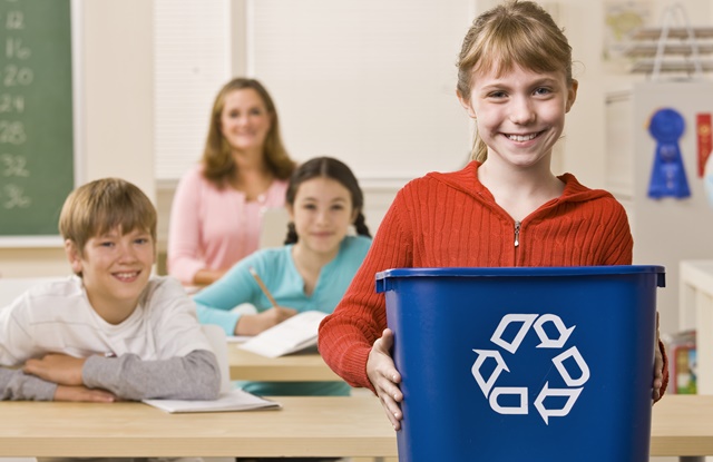 foto de criança segundo lixo com símbolo de reciclagem
