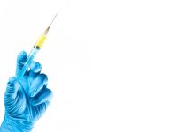 foto de mão com luva segurando vacina
