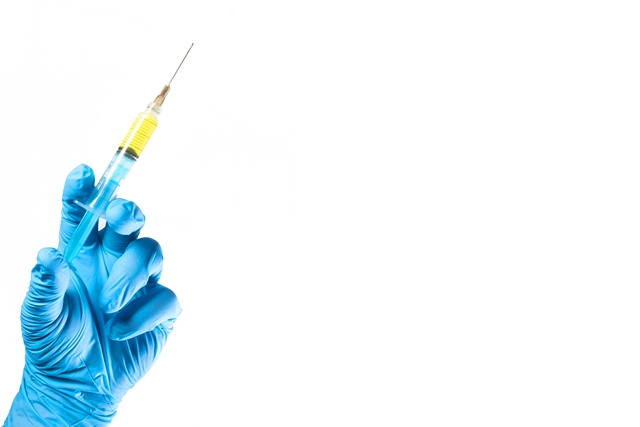 foto de mão com luva segurando vacina