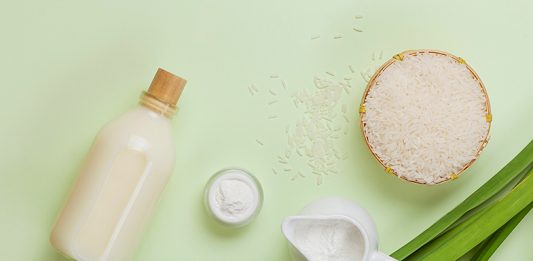 Milk and rice in bowl on light background.