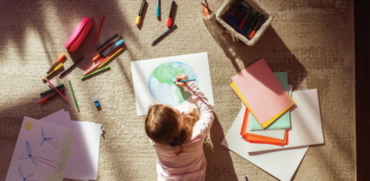 Top View: Little Girl Drawing Our Beautiful Green Planet Earth.